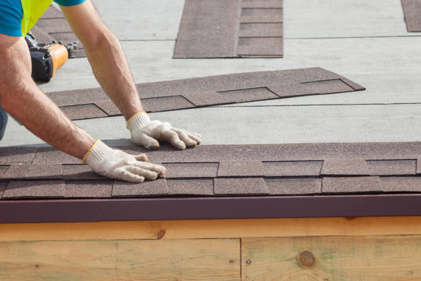 Roofer builder worker installing roof shingles.